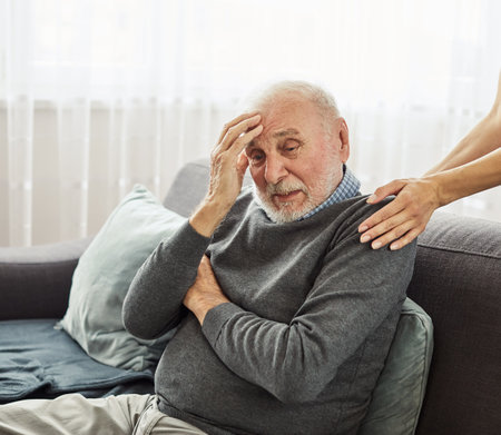 Doctor or nurse caregivers hand giving support to sad lonely senior man at home or nursing homeの写真素材