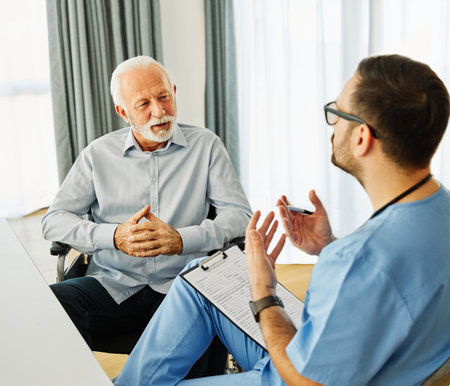 Doctor or nurse caregiver with senior man in a wheelchair holding a document paperwork at home or nursing homeの写真素材