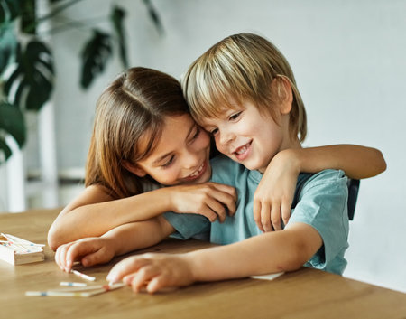 Portret of brother and sister having fun together playing board game pick-up sticks at homeの写真素材