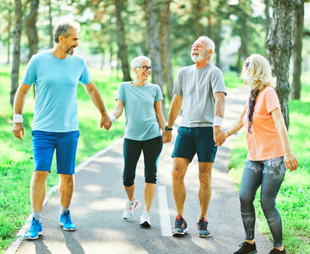 Smiling active senior people jogging together in the parkの写真素材