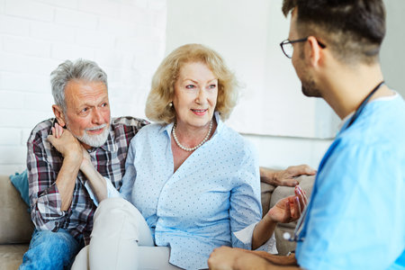 Doctor or nurse caregiver with senior couple at home or nursing homeの写真素材