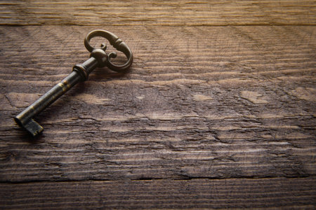 Vintage key on a wooden chocolate background with solar Blick