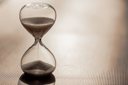 Close up of hourglass clock. Hourglass time passing concept for business deadline, urgency and...