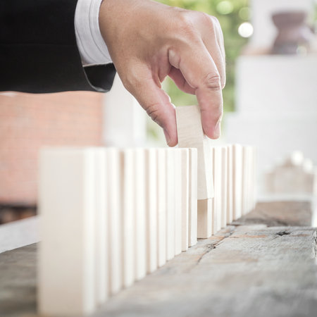 Managing policy concept: Businessman choosing wood block.の写真素材