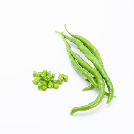 Green chillies with chopped pieces on white backgroundの写真素材