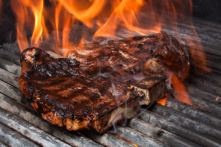 T-Bone Steak on Barbecue Grill Flamesの写真素材