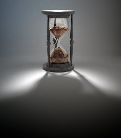 An antique hourglass casting a long shadowの写真素材