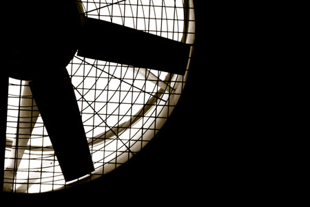 Industrial fan turbine behind a metal grate, with copy space