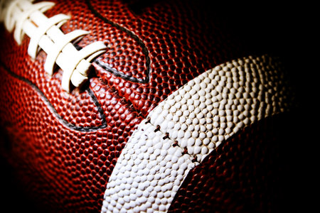close up of an american football against a black backgroundの写真素材