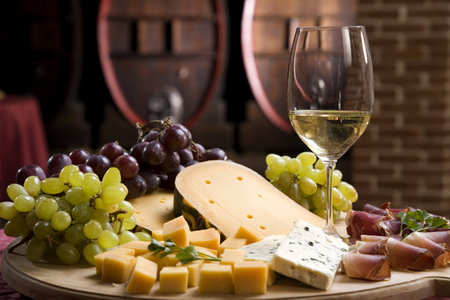 White wine in fine glass with cheese and grapeの写真素材