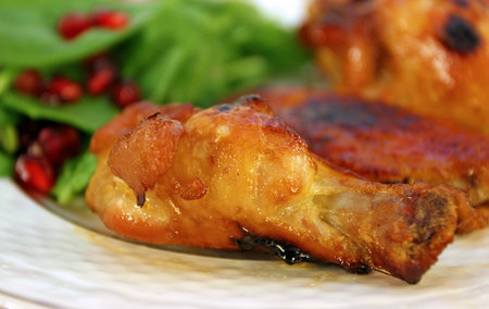 grilled chicken with pomegranate and salad on a plateの写真素材