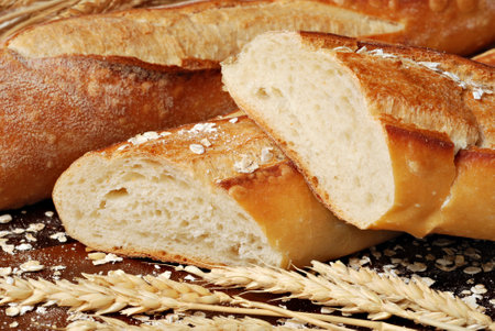 Freshly baked french baguettes with oats and wheat spikes. Macro with shallow dof.の写真素材