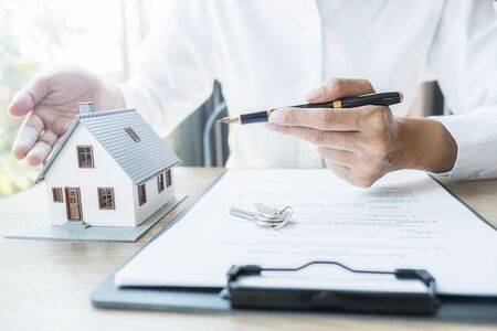 House model with agent asking costumer for contract to buy, get insurance or loan real estate or property.の写真素材