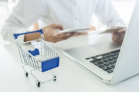 Young woman holding credit card and using laptop computer. Online shopping concept.の写真素材