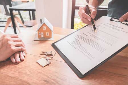 House model with agent and customer discussing for contract to buy, get insurance or loan real estate or property.の写真素材