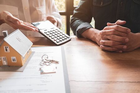 House model with agent and customer discussing for contract to buy, get insurance or loan real estate or property.の写真素材