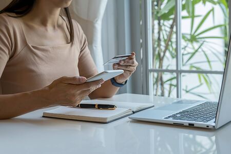 Happy asian woman doing online shopping at home. Online payment and shopping concept.の写真素材