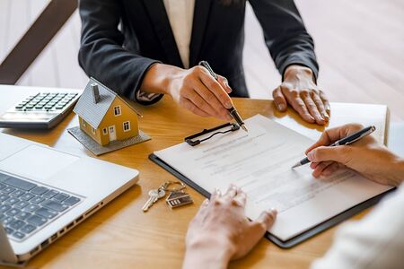 House model with agent and customer discussing for contract to buy, get insurance or loan real estate or property.の写真素材