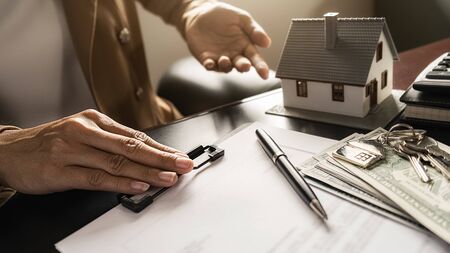 House model with agent and customer discussing for contract to buy, get insurance or loan real...