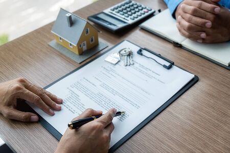 House model with agent and customer discussing for contract to buy, get insurance or loan real...