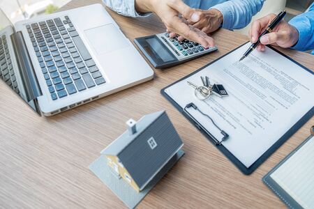 House model with agent and customer discussing for contract to buy, get insurance or loan real estate or property.の写真素材