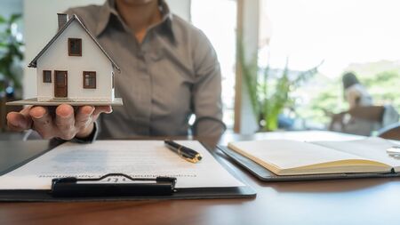 House model with agent asking costumer for contract to buy, get insurance or loan real estate or...