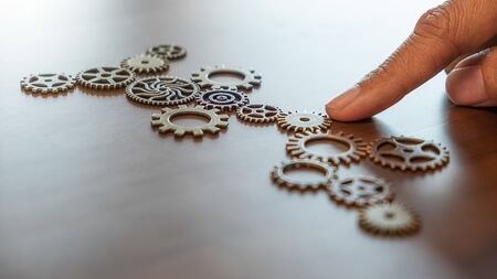 Business Solutions for Success and Strategy. Businessman hands connect the gears with a puzzle. Fulfill and fix the problem of incomplete teamwork.の写真素材