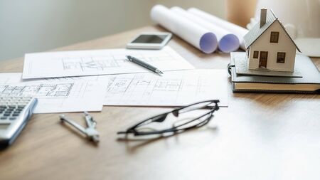 Engineering or Architect tools, blueprint and house model on table in office. Construction concept.