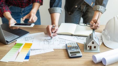 Interior designer and Architect choosing color in color swatch samples chart for house coloring selection in office with blueprint. Construction concept.の写真素材