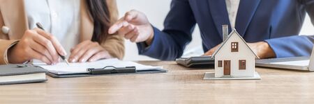 House model with agent and customer discussing for contract to buy, get insurance or loan real estate or property.の写真素材