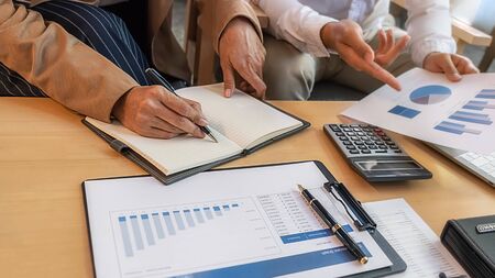 Business team brainstorming and discussing with financial data and report graph. Teamwork meeting...