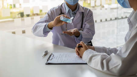 Doctor recommending washing hand with alcohol sanitizer gel to avoid contaminating with Coronavirus for general people in the hospital. Medical and Health concept.の写真素材