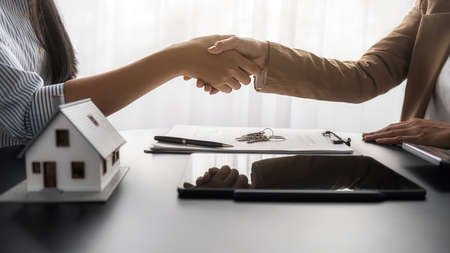 House model with agent and customer discussing for contract to buy, get insurance or loan real estate or property.の写真素材