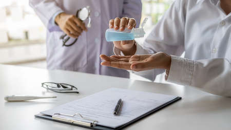 Doctor recommending washing hand with alcohol sanitizer gel to avoid contaminating with  for general people in the hospital. Medical and Health concept.の写真素材