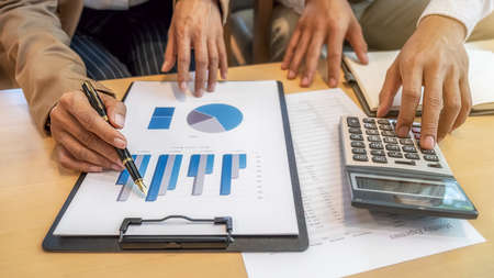Close-up of businessman hand using calculator to calculate business data, accountancy document at...