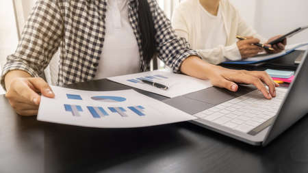 Business woman using laptop to checking the company performance chart. Business concept.