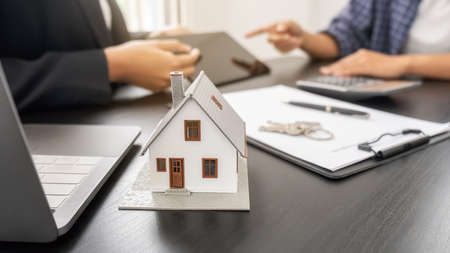 House model with agent and customer discussing for contract to buy, get insurance or loan real...