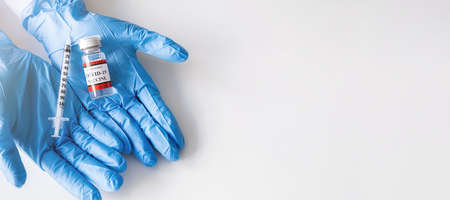 Covid-19 coronavirus vaccine bottle and syringe injection tool for covid19 immunization treatment on doctor hand. Healthcare and Medical concept.の写真素材