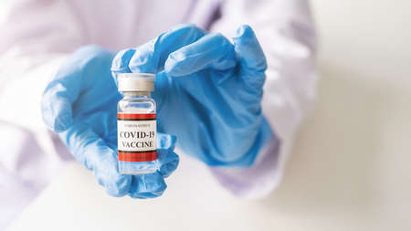 Covid-19 coronavirus vaccine bottle on doctor hand. Fight against Covid-19 coronavirus Concept.の写真素材