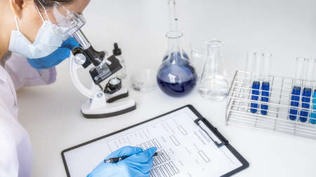 Scientist working with microscope for vaccine development in pharmaceutical research laboratory....