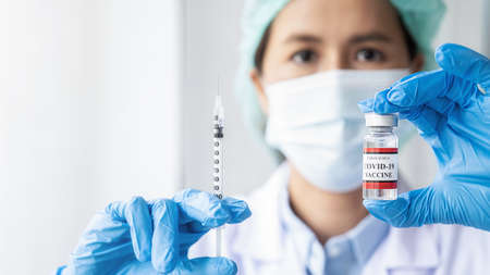 Doctor filling syringe medication with Covid-19 coronavirus vaccine. Fight against Covid-19 coronavirus Concept.の写真素材