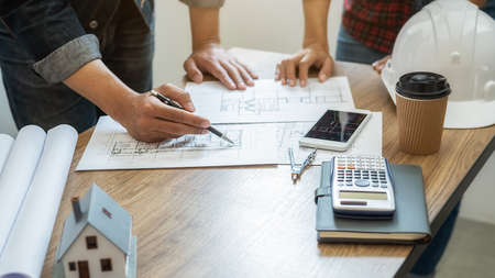 Interior designer choosing color in color swatch samples chart for house coloring selection in office with blueprint. Construction concept.の写真素材