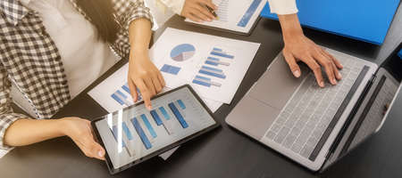 Business woman using tablet to checking the company performance chart in the office. Business...