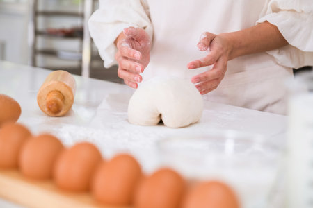 Mid section of woman kneading dough in the kitchen at homeの写真素材