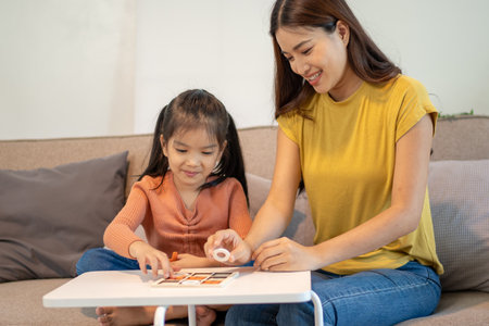 Lovely mom and little young daughter spending time together in their living room.