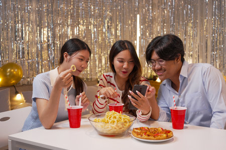 Three asian female friends eating pizza and drinking soda in a bar