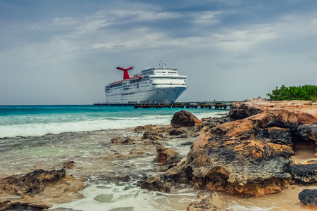 Grand Turk / Turks and Caicos Islands - May 10.2007: View on the Cruise Ship dock by the pier. Turquoise color of the sea, cloudy sky.  Rocky beach in the front of the frame.のeditorial素材