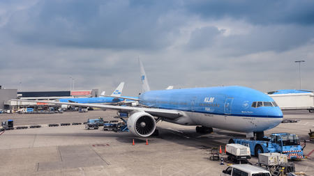 Amsterdam / Netherlands - 07.09.2017: KLM airplane Boeing 777 at the Schiphol Airport standing by the terminal withe the dark blue clouds in the background.のeditorial素材