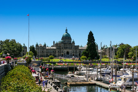 Victoria, BC / Canada- July 26.2006: View of Victoria Inner Harbour and British Columbia Provincial Parliament Building with lots of people walking during sunny day with blue sky.のeditorial素材