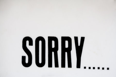 Sign that says SORRY...  Close-up, full frame, handmade white background with black typeの写真素材